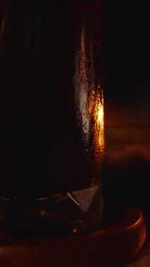 Yakınlarda Parlayan Mum ve Tabak Üzerinde Yemek Parçaları olan Büyük Bardak Koyu İçecekle Samimi TV Zaman kavramını kapatın