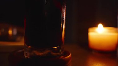 Masanın Arkasında Mum Alevli Koyu İçecekle Sıcak Sönük Odası 'nda Tabak ve Yemekli Gevşek Televizyon Zamanı kavramını kapat