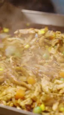 Dikey video. Sokak satıcılarının kepçelerini kapatıyoruz. Kızarmış erişte ve sebzeleri plastik tepsiye koyup gece pazarında servis etmek üzere marul koyuyoruz. Sokak Gıda Konsepti.