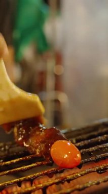 Dikey video. Izgara et şişi ve domatesli fırçalama sosu sıcak ızgara, sığ alan derinliği, sokak yemekleri konsepti.