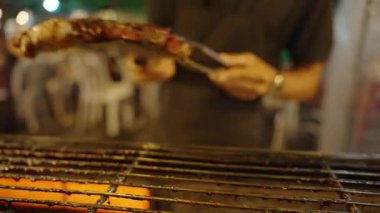 Izgara kaburgaların yakın çekim yeri sıcak ızgaranın altında parlak közler, sığ odak, sokak yiyecekleri kavramı