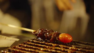 Sos damlayan ızgarada domatesli jöleli et şişi. Düşük açılı, sokak yemeği kavramı.