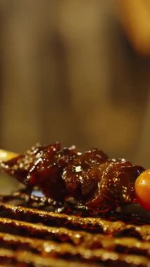 Dikey video. Sos damlayan ızgarada domatesli jöleli et şişi. Düşük açılı, sokak yemeği kavramı.