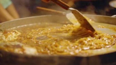 Yavaş Çekim Pad Tayland Eriştesi. Tayland pazarında Spatula in Large Hot Pan, yakın açı, Sokak Gıda Konsepti.