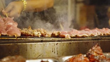 Slow Motion Tedarikçisi Gece Marketinde Yanan Duman Izgarası 'nda Domuz Şişi Döndürüyor, Yakın açı, Sokak Gıda Konsepti