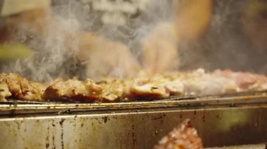 Slow Motion Izgara Domuz Pieces Gece Marketi 'nde Smoky Charcoal Grill' de cızırdıyor, düşük açı, Sokak Gıda Konsepti