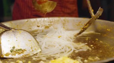 Angle Slow Motion Şefi Sos ve Çiğ Pad Tayland Eriştesini Büyük Sıcak Tavada Metal Utensillerle Karıştırıyor, Sokak Gıda Konsepti