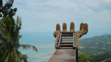 Boş büyük ahşap el, kıyı şeridi ve okyanus üzerinde güneşli mavi gökyüzü altında, geniş açı manzaralı, çakışan taş Koh Samui kavramı.
