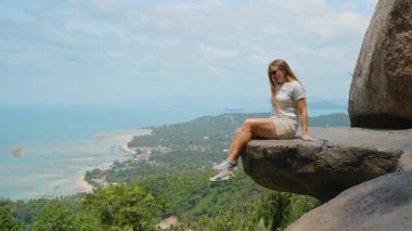 Geniş Kaya Denizi 'nin Kıyısında Oturan Genç Kadın ve Geniş Açı' dan Uzak Adalar Üst Kaya Samui 'de Düşük Açı, Özgürlük Yolculuğu Konsepti