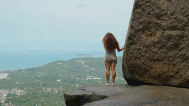 Genç Kadın Okyanus manzarasına bakan dev kayalara karşı duruyor Samui 'de, Doğa Keşfi