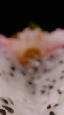 Dikey video. Dolly Kaydırıcı Beyaz Ejder Meyvesi Görünümü Parlak Pembe Arkaplan Altında Siyah Tohumlar Kabuğu, Tropikal Meyve Konsepti