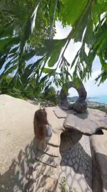 Dikey video. Dar Taş Basamaklara Tırmanan Kadın Koh Samui 'deki Kemer Kayası' na doğru tutunuyor.