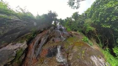 Islak kayalara tırmanan adam Koh Samui Ormanı ile çevrili Akan Şelale Geniş Açı Açı Kavram Macerası