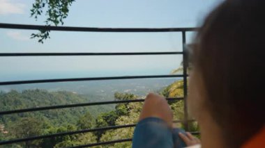 Terasa yaslanan ve Metal Demiryolları, Farkındalık ve Seyahat Konsepti ile Uzak Okyanus ve Dağ Manzarasına Bakan Kadın