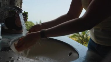 Akan Su ve Arkaplanda Dağ Görünümü, Hijyen ve Temizlik Konsepti ile Dışarda Elleri Yıkama Kişi