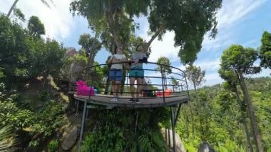 Ağaç Güvertesinde Birlikte Ayakta Duran İki Kişi Orman ve Gökyüzüne Bakar Etrafı bereketli bitki örtüsü, Geniş Açı, Arkadaşlık ve Seyahat Konseptiyle çevrili