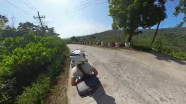 Scooter 'da Erkek Şoförün Arkasında Oturan Kadın Dağ Yolu boyunca Lastik Engelleri, Arka Açı, Sahne Gezisi Konsepti