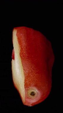 Dikey video. Yarı Gül Elma Haçı Bölümü Siyah Arkaplan Dönüşümlü Sulu Beyaz Çekirdek ve Pürüzsüz Kırmızı Cilt, Döngü Stüdyosu İzole Taze Meyve Konsepti