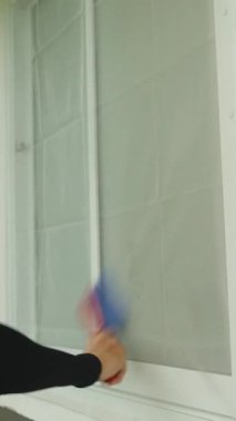 Dikey video. Gündüz vakti Siyah Kol Giyen Kırmızı ve Mavi Fırça ile Pencere Fırçalama Ekranı