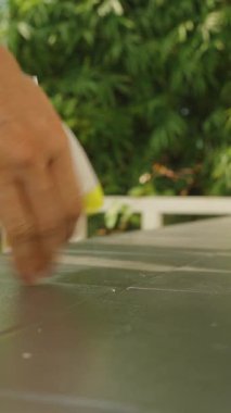 Dikey video. Açık Masa Masası Yüzeyini Parlak Güneş Işığıyla Temizleyen Yeşil Yapraklar