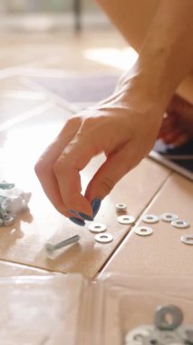 Dikey video. Elle konteynıra vida yerleştirirken zeminde çapraz bağlama, donanım organizasyonu konsepti yakın görünüm