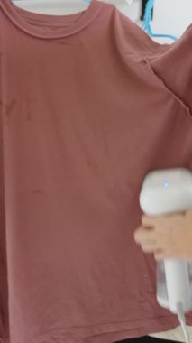 Dikey video. Vapur, Yan Açı, Çamaşır Bakımı Konsepti kullanan Koyu kahverengi tişörtlü Kadın Yumuşatıcı