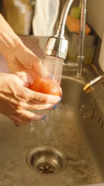 Dikey video. Mutfak lavabosundaki Suyun Altında İnsan Yıkama Domatesi Sağlıklı Yeme Konsepti