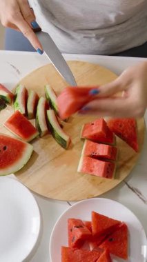 Dikey video. Masada Tabaklar ve Sağlıklı Yeme Konseptiyle Karpuz Kesen Kadın Görünümü