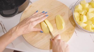 Yakınlarda Süzgeç ve Ot Otu Konseptiyle Patates Kesen Kadın Yuvarlak Tahta Kurulunda Genel Görünüm, Ev Pişirme Konsepti