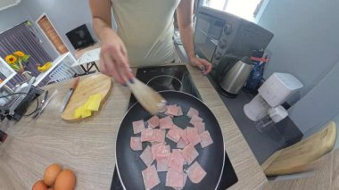 Yapışkan Olmayan Tavada Küçük Jambon Parçalarını Kızartan Kadın Ahşap Spatula Kullanıyor, Geniş Açı Mutfak Görünümü Hafif Fisheye Efekti, Kahvaltı Hazırlama Konsepti