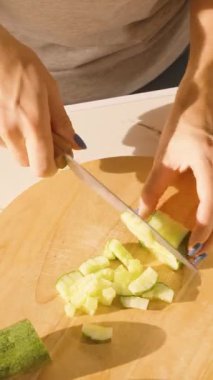 Dikey video. Yuvarlak Tahta Üzerinde Taze Salatalık Kesen Kadın, Yakın Açı, Salata Hazırlama Konsepti