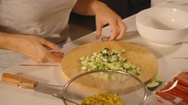 Kadın Doğranmış Salatalıkları Beyaz Bowl, Yan Açı, Taze Salata Hazırlama Konseptine Döküyor