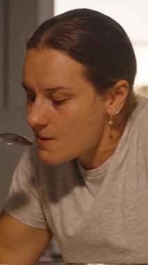 Dikey video. Mutfak Masası, Yan Açı, Tat Gıda Konsepti 'nde Yemeden Önce Yemek Yiyen Kadın