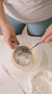 Dikey video. Metal Sifter ile Kadın Yumurta Karışımı, Üst Açı, Fırın Süreci Konseptine Un Ekliyor