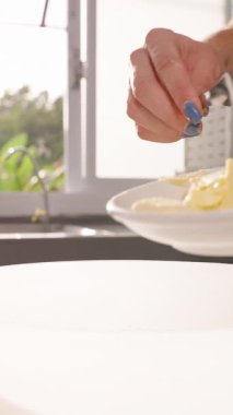 Dikey video. Plate 'den White Bowl' a Tereyağı Küpleri Eklemek Parlak Mutfak Işığı, Yavaş Hareket, Pişirme İçindekiler