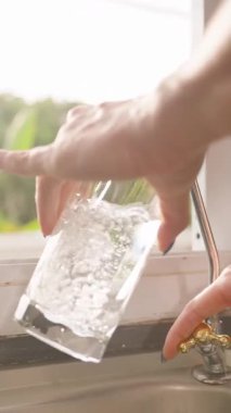 Dikey video. Kitchen Window, Slow Motion, Household Utility Concept yakınlarındaki Suyu Kaparken Eller Kapalı Camı Musluğun Altında