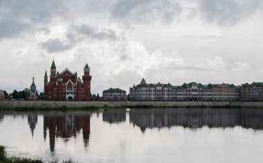 Ulusal Kukla Tiyatrosu ve güzel evler bulutlu bir günde suya yansıdı. Yoshkar-Ola city, Mari El, Rusya Federasyonu.