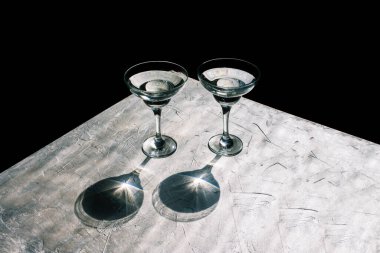 Doğal gölgeli cam bardaklar. Gümüş ve siyah arka plan. Asgari yaratıcı biçim.