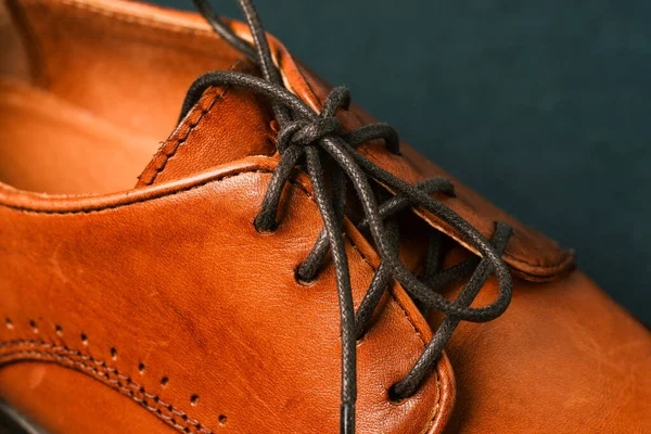 Часть мужской обуви крупным планом. Сосредоточься на черных шнурках. Мужская обувь из натуральной кожи. Коричневая обувь. — стоковое фото