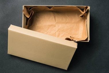 Open empty box with a lid, isolated on a black background. Cardboard box for shoes or gift. Top view, flat layout. clipart