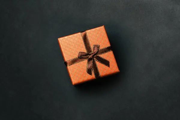 Caja de regalo con cinta sobre fondo oscuro. Embalaje de vacaciones marrón para cumpleaños, Navidad, boda y otro evento festivo. vista superior de una disposición plana —  Fotos de Stock
