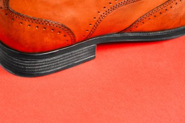 Erkek ayakkabıları yakın - kırmızı arka planda, boşluğun bir kopyasıyla birlikte. Erkek modası. Ayakkabı satışı ve teslimatı..