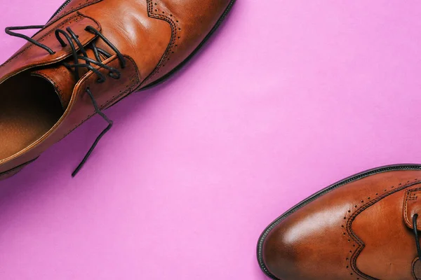 Мужская коричневая обувь на фиолетовом фоне с копией пространства. Доставка и продажа обуви — стоковое фото