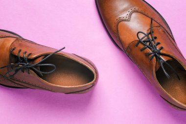 Deri erkek ayakkabıları. Renkli arka planda kahverengi ayakkabılar. Ayakkabı teslimatı ve satışı kavramı.