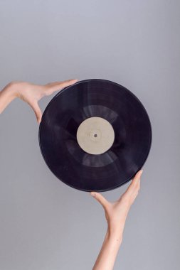 Parlak arka planda, retro tarzı izole vinil kaydı tutan el