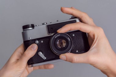 Retro fotoğraf makinesi gri duvar arka planda tutan eller