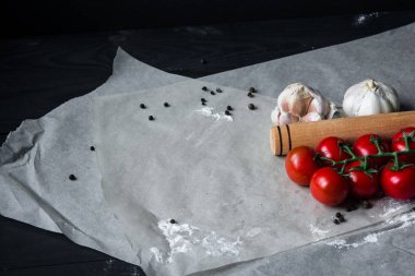 Gıda arka plan. Düz taze domates, sarımsak ve spise kagit üzerinde yatıyordu. Soldaki kopya alanı ile Üstten Görünüm