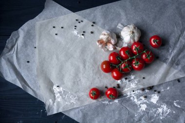 Gıda arka plan. Düz taze domates, sarımsak ve spise kagit üzerinde yatıyordu. Soldaki kopya alanı ile Üstten Görünüm