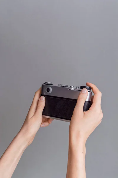 灰色の壁背景の女性両手レトロ写真カメラ — ストック写真