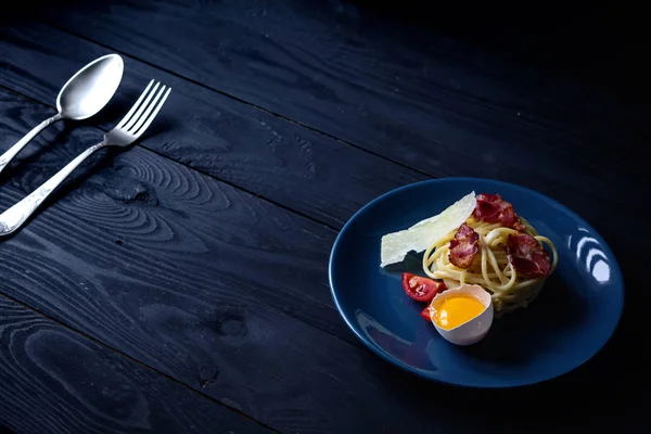 Bir tabloda makarna carbonara koyu arka plan, kopya alanı, gıda arka plan üzerinde taze ürünlerle  